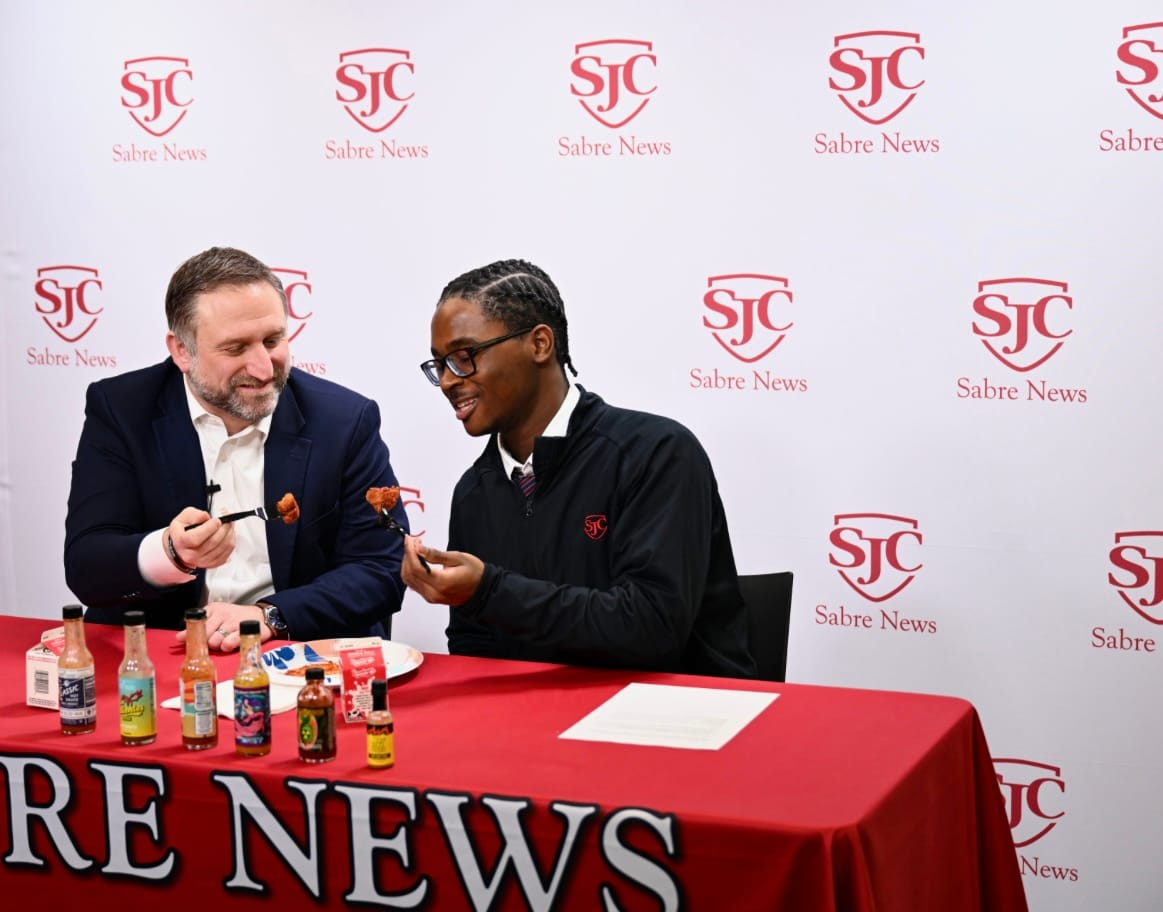 Host and guest on Six Burning Questions get ready to eat hot nuggets